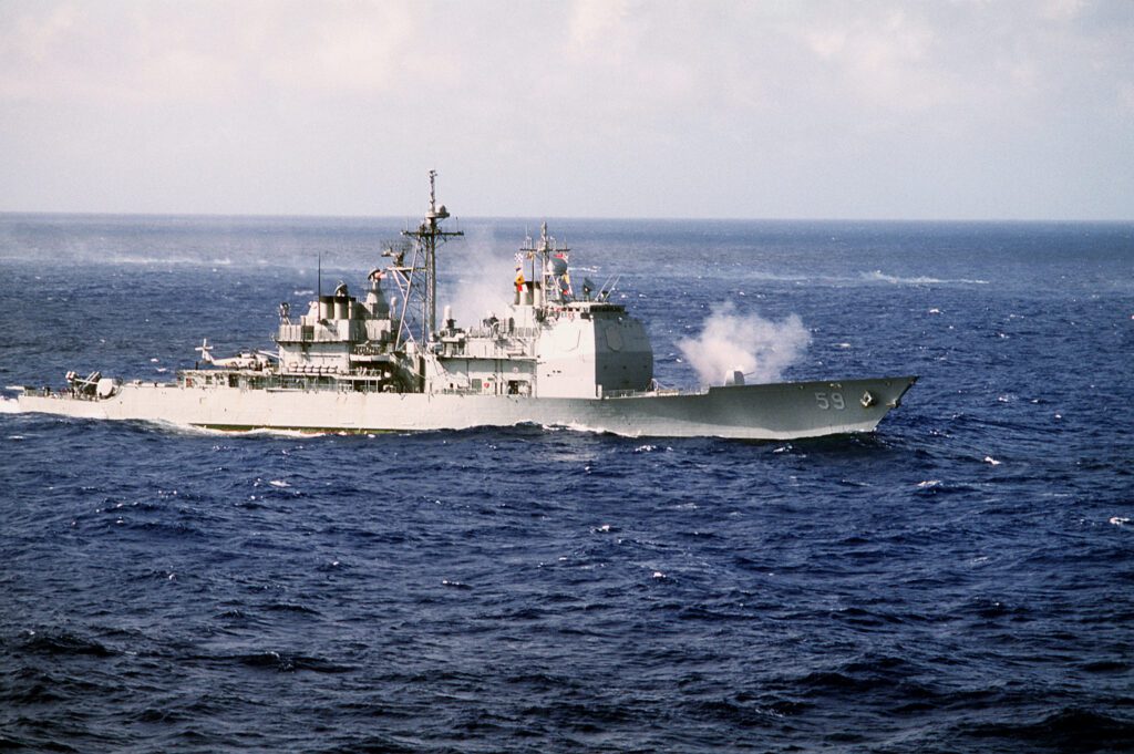 A starboard bow view of the guided missile cruiser USS PRINCETON (CG-59) underway during a gunnery exercise. The ship's forward Mark 45 5 inch/54 caliber gunmount is shown firing t